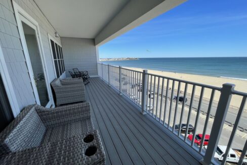 a balcony with wicker furniture and a view of the beach.