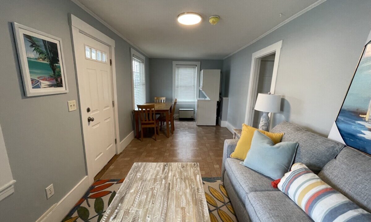 a living room filled with furniture and a painting on the wall.