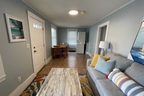 a living room filled with furniture and a painting on the wall.