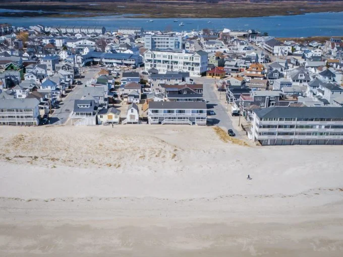 Aerial view of a coastal town with buildings adjacent to a sandy beach.