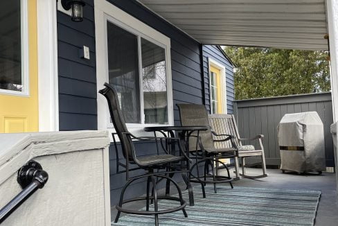 a porch with a table and chairs on it.