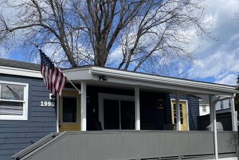 a blue house with a flag on the porch.