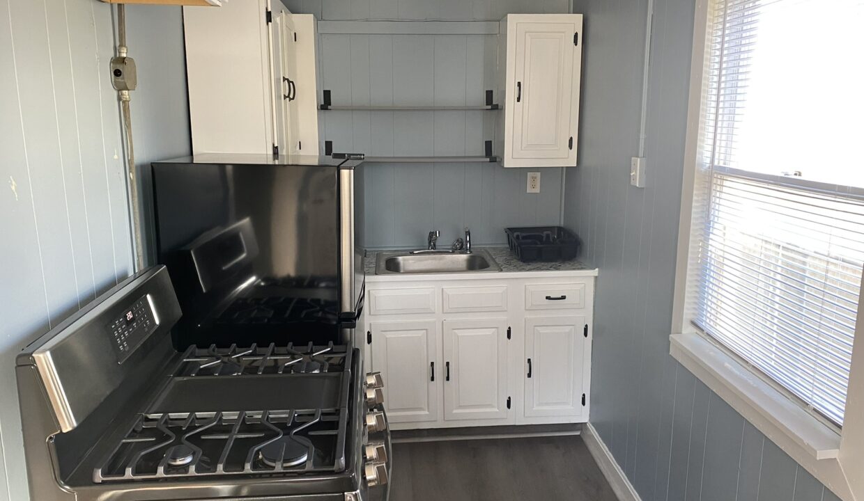 a kitchen with a stove top oven next to a window.