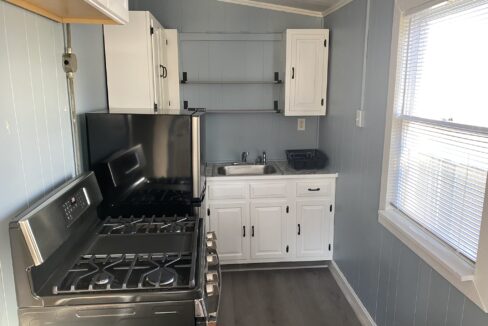 a kitchen with a stove top oven next to a window.