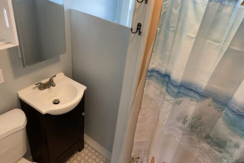 a bathroom with a sink, toilet, and shower curtain.