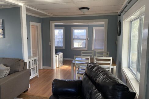 a living room filled with furniture and a wooden floor.