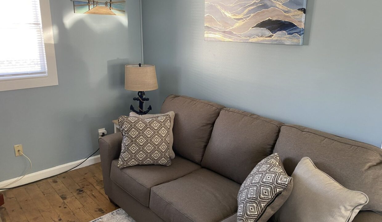 a living room with a couch and a lamp.