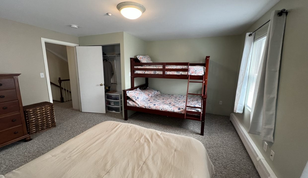 a bedroom with a bunk bed and a dresser.