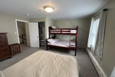 a bedroom with a bunk bed and a dresser.