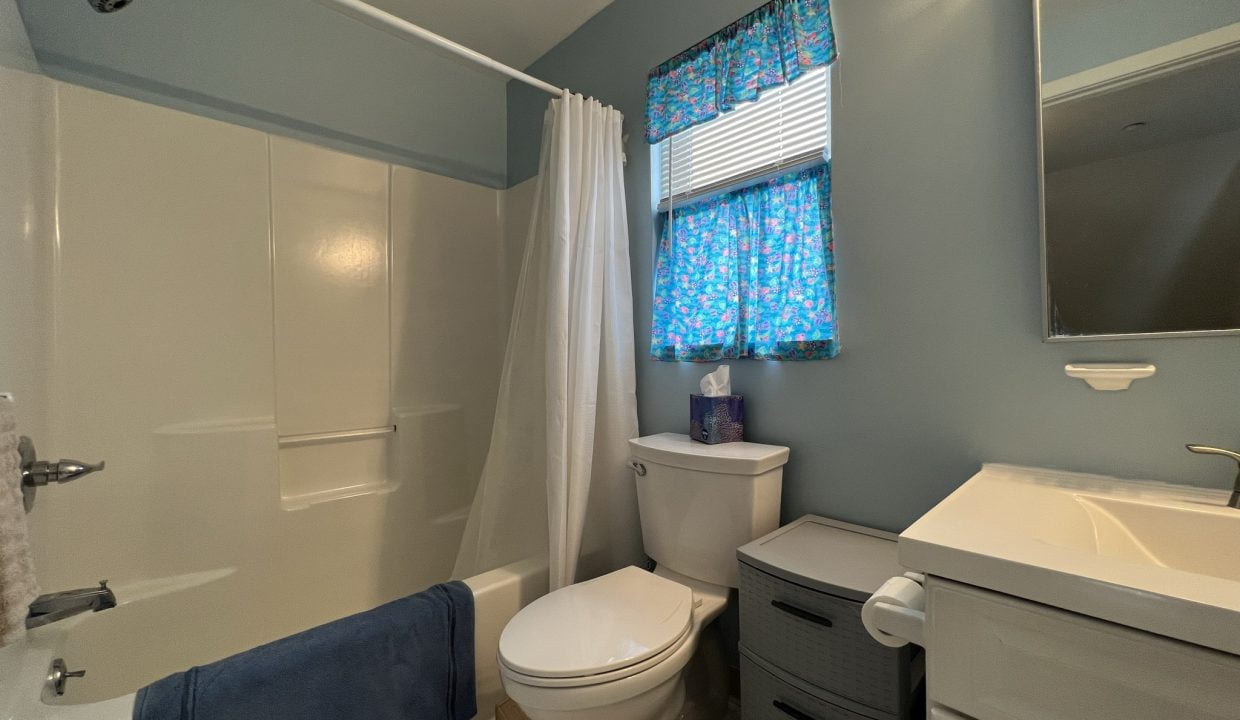 a white toilet sitting next to a bath tub.