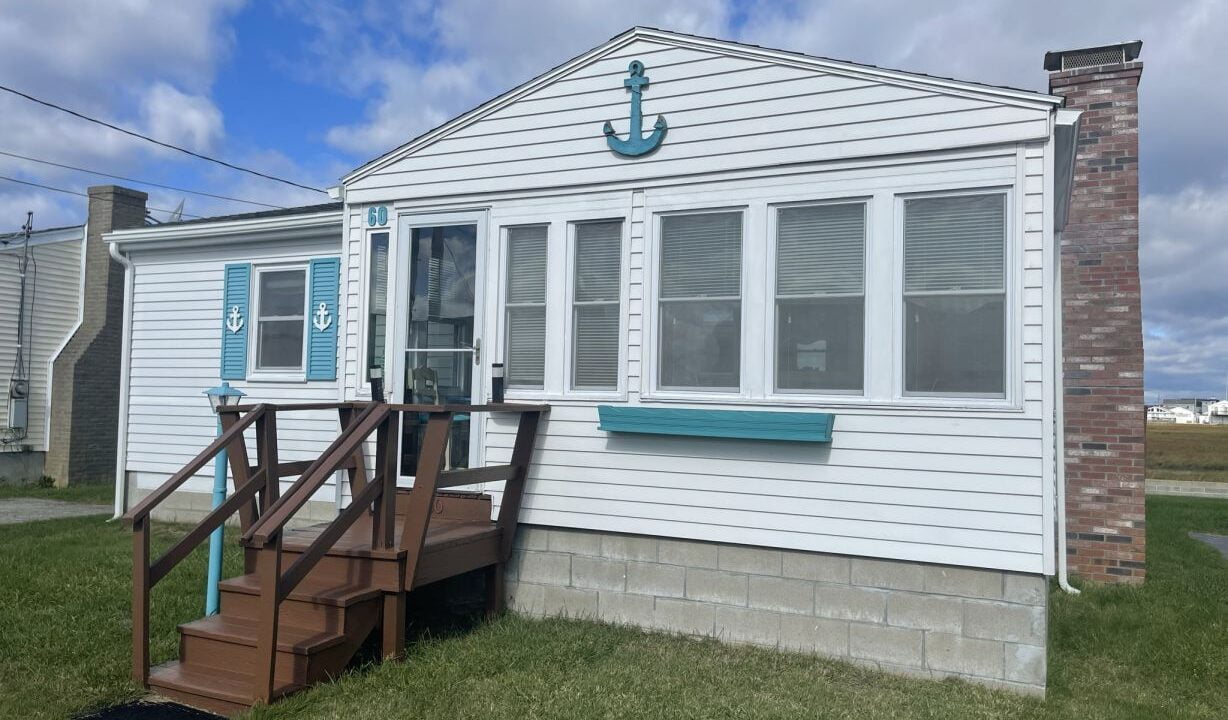 a white house with a blue anchor on the door.