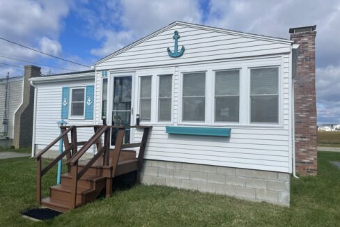 a white house with a blue anchor on the door.