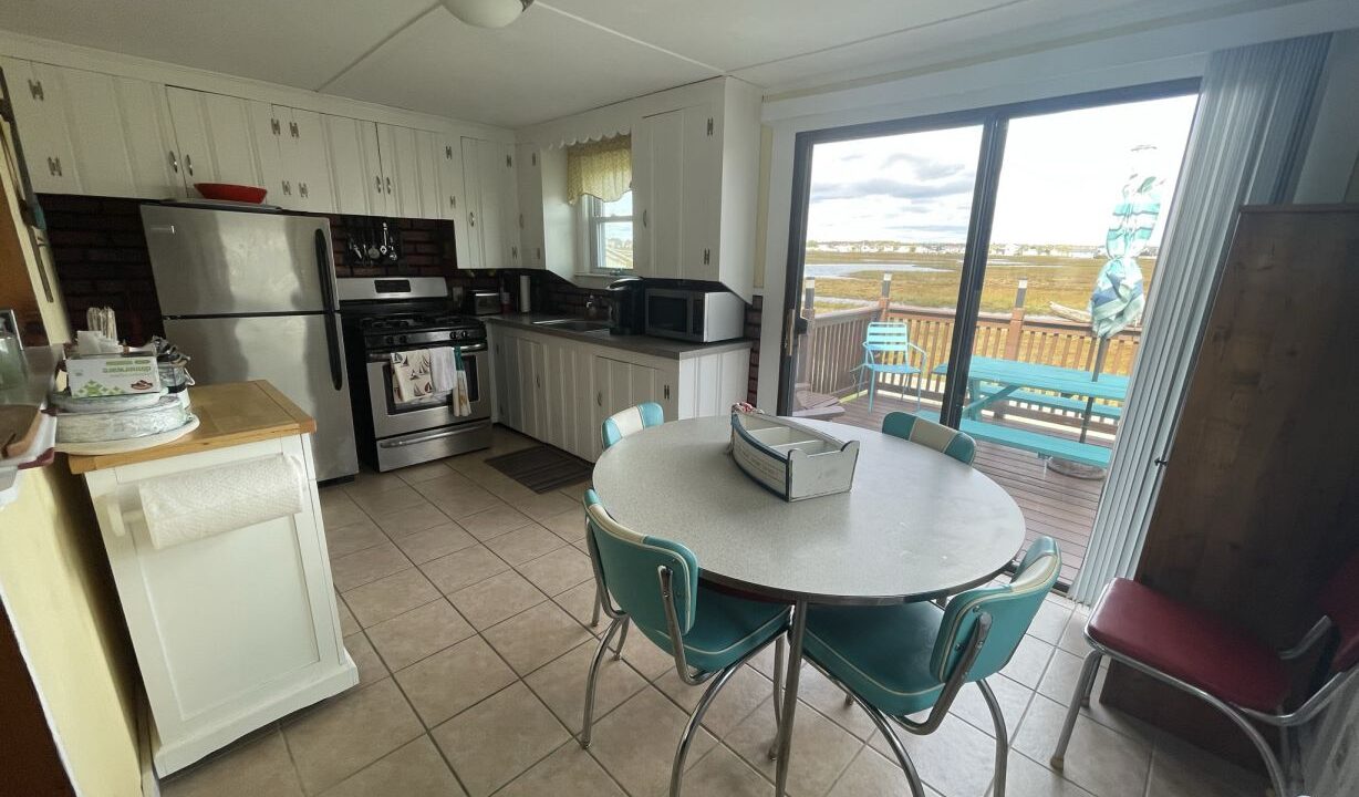 a kitchen with a table and chairs and a sliding glass door.