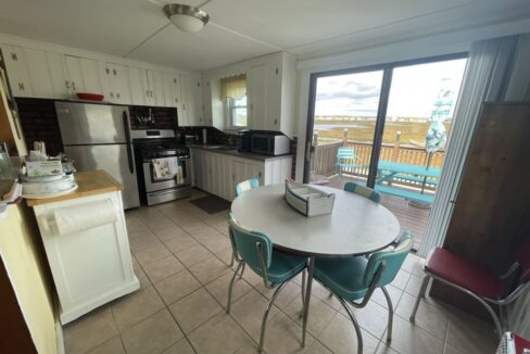a kitchen with a table and chairs and a sliding glass door.