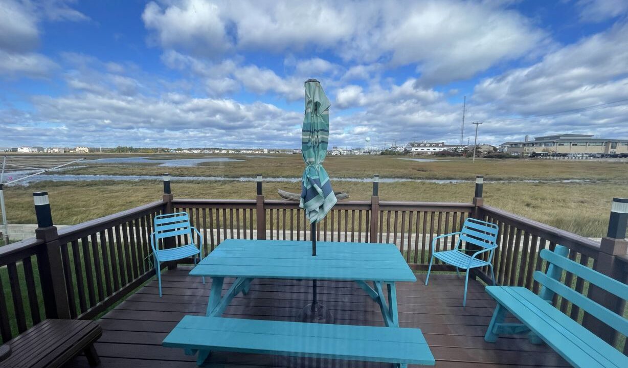 a blue picnic table sitting on top of a wooden deck.