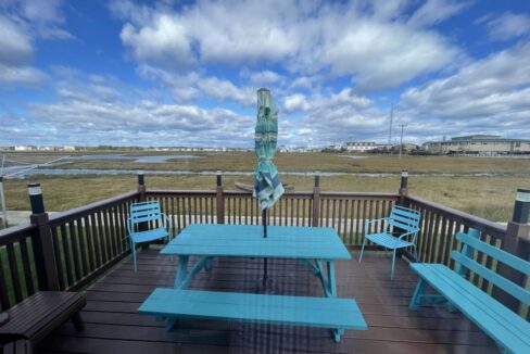 a blue picnic table sitting on top of a wooden deck.