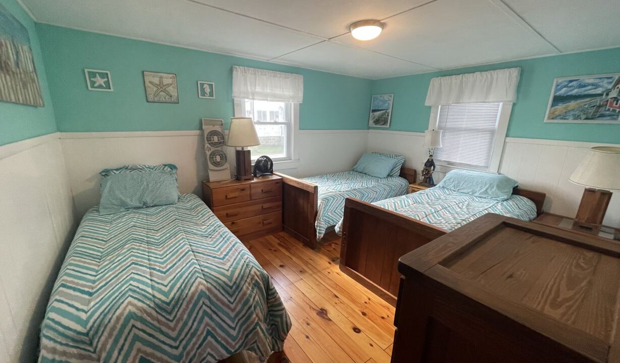 a bedroom with two beds and a dresser.