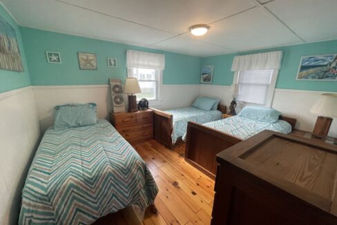 a bedroom with two beds and a dresser.