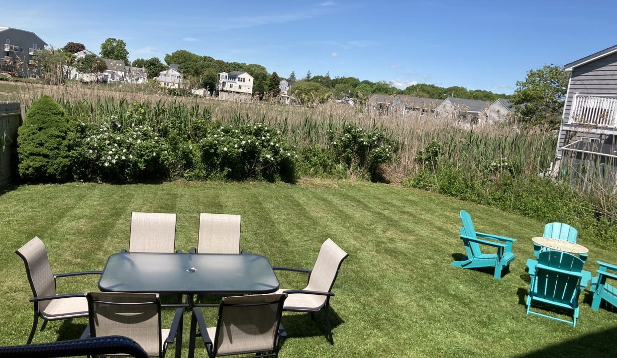 a table and chairs sitting on top of a lush green field.