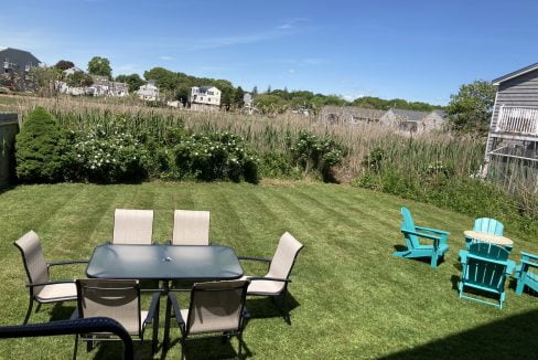 a table and chairs sitting on top of a lush green field.