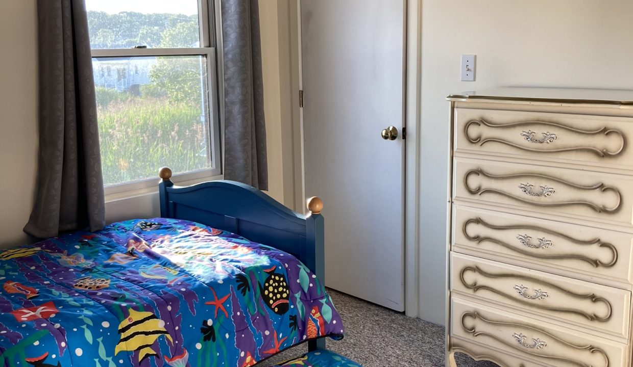 a bedroom with two beds and a dresser.