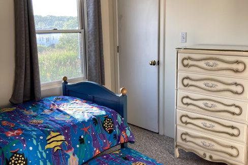 a bedroom with two beds and a dresser.