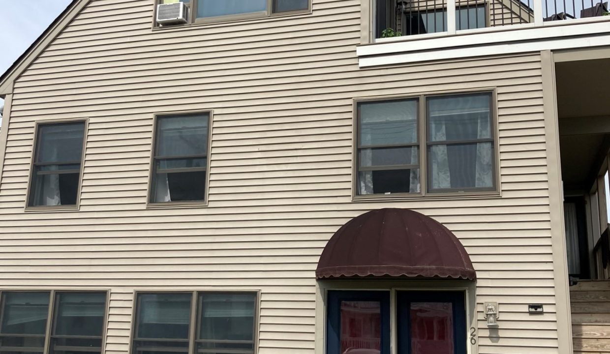 a two story house with a blue door.