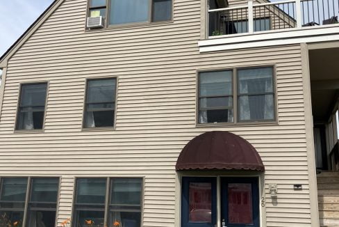 a two story house with a blue door.