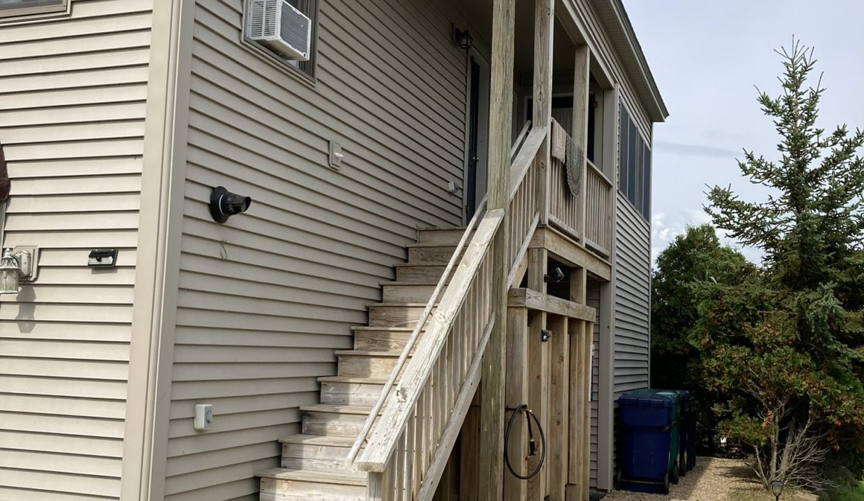 a house with a staircase leading up to the second floor.