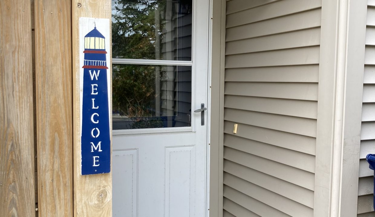 a white door with a welcome sign in front of it.