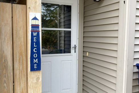 a white door with a welcome sign in front of it.