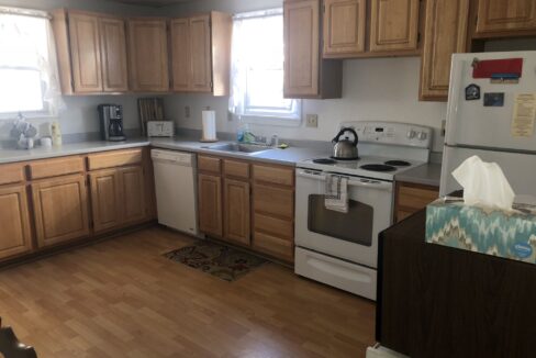 a kitchen with wooden floors and white appliances.