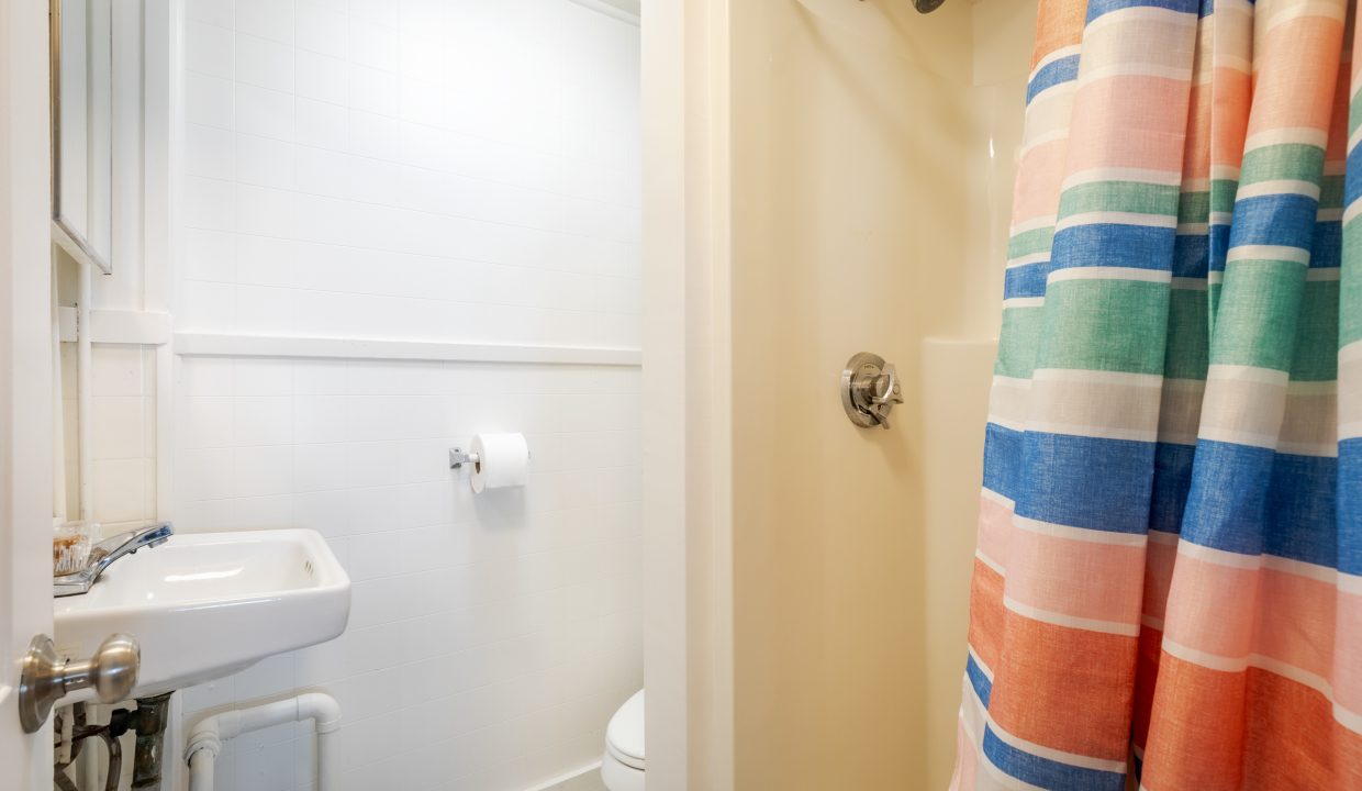 a bathroom with a colorful shower curtain.