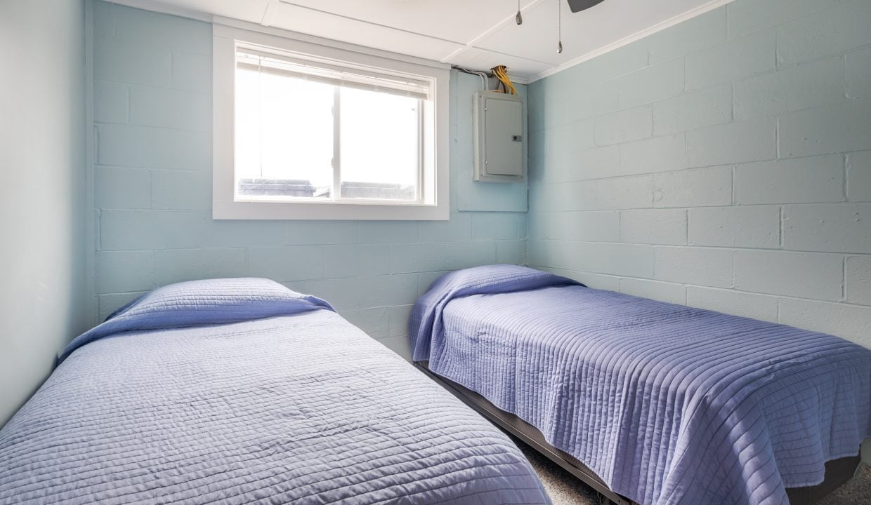 two beds in a room with a ceiling fan.