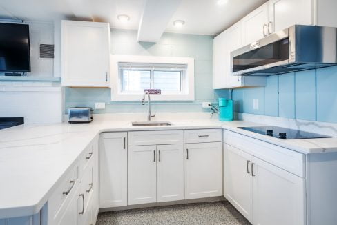 a kitchen with white cabinets and blue walls.