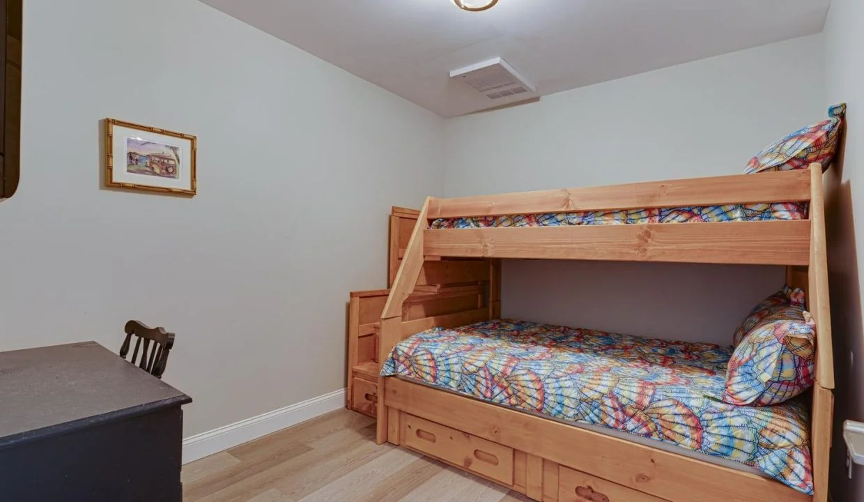 a bedroom with a bunk bed and a desk.