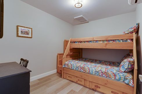 a bedroom with a bunk bed and a desk.