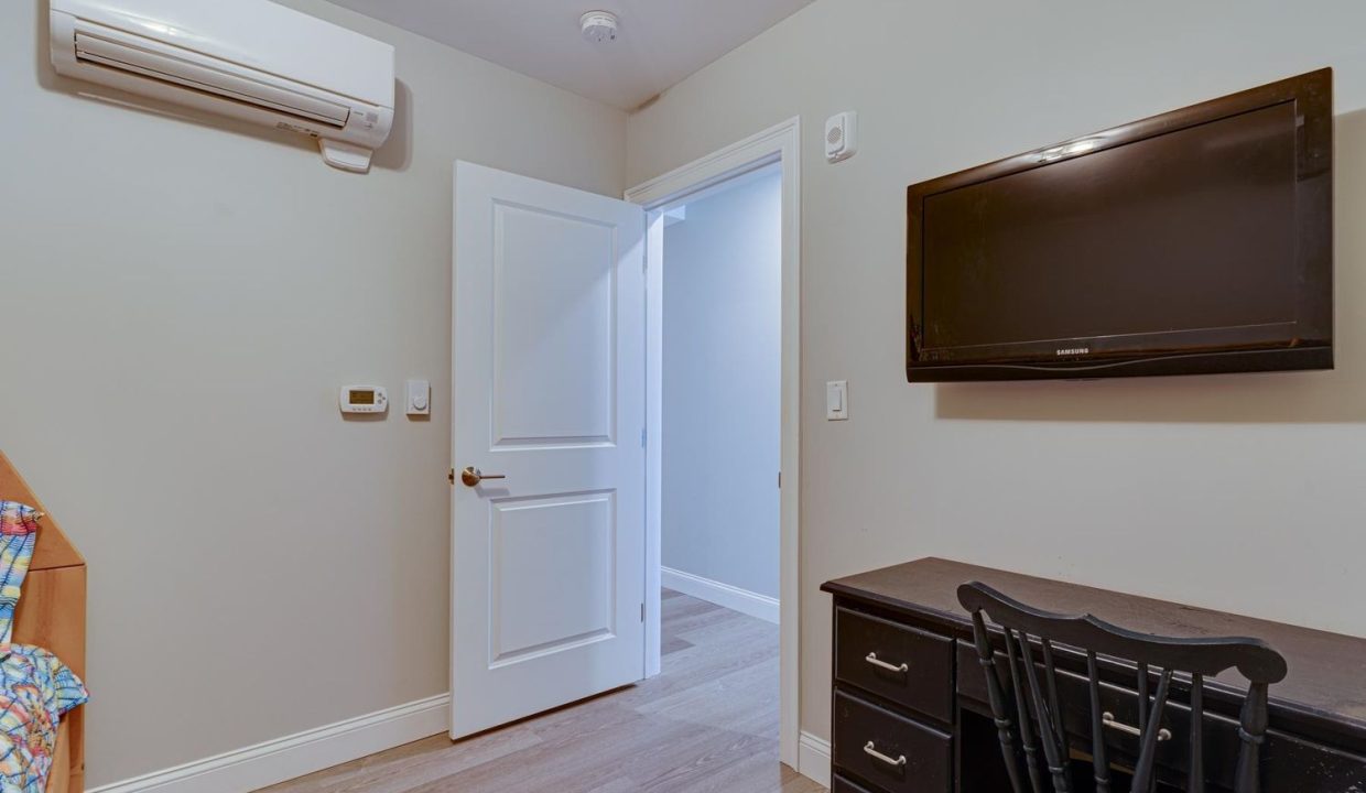 a room with a television and a dresser in it.