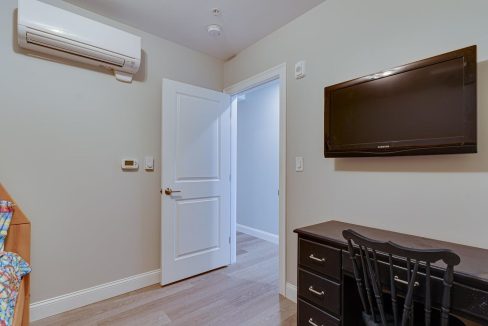 a room with a television and a dresser in it.