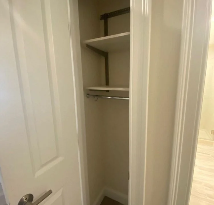 an empty closet with a door open to reveal a closet.