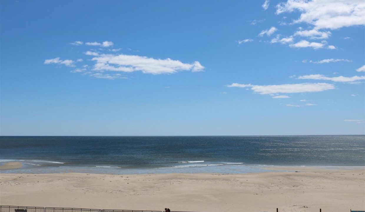 a person walking on a beach next to the ocean.