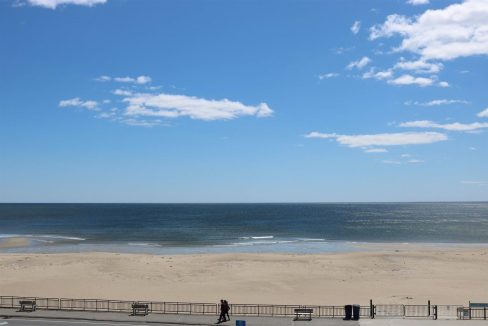 a person walking on a beach next to the ocean.