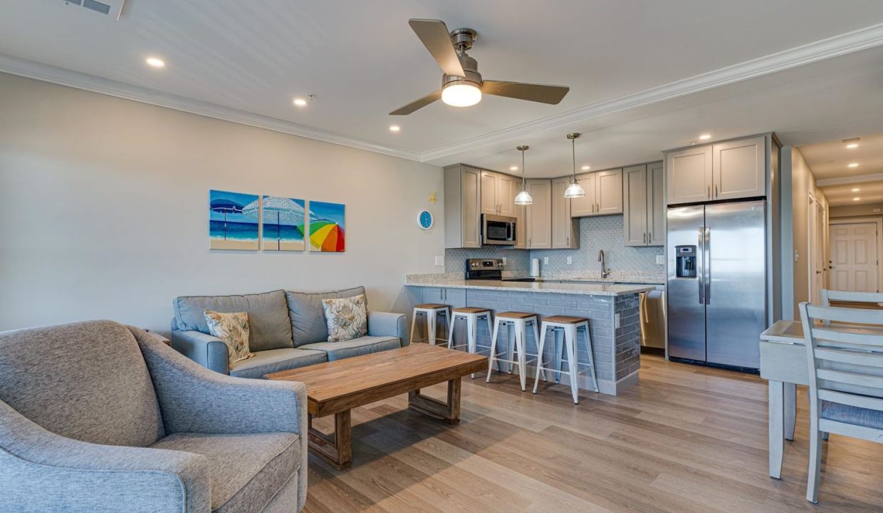 a living room filled with furniture and a kitchen.