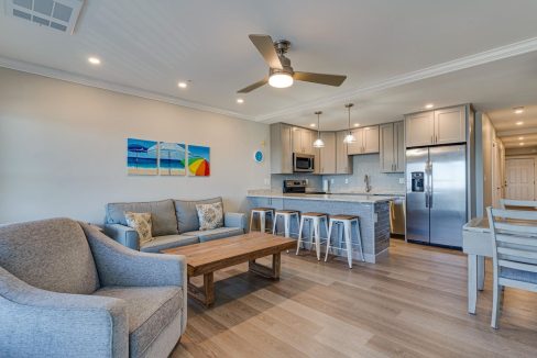 a living room filled with furniture and a kitchen.