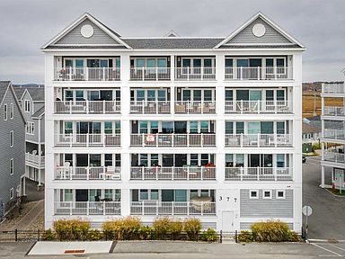 a large white building sitting next to a parking lot.