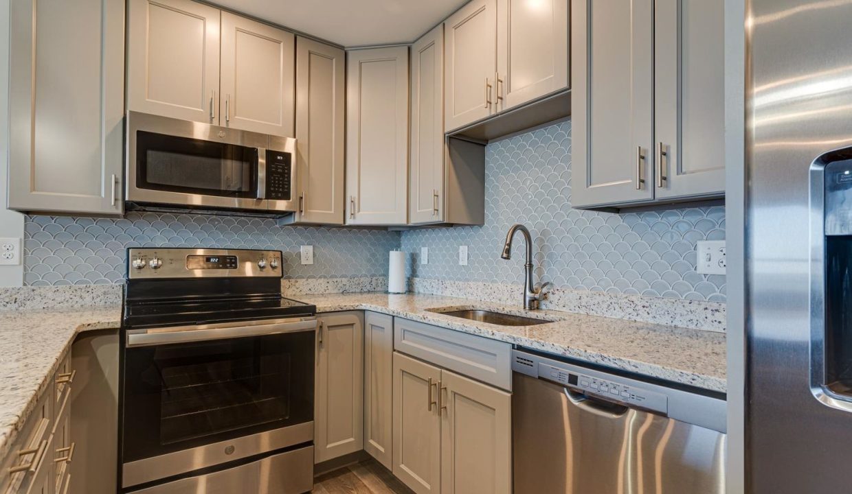 a kitchen with stainless steel appliances and white cabinets.