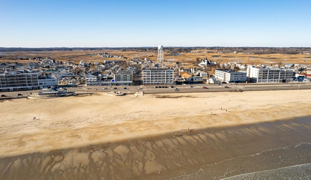 an aerial view of a beach with a city in the background.