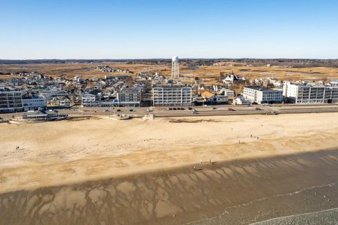 an aerial view of a beach with a city in the background.