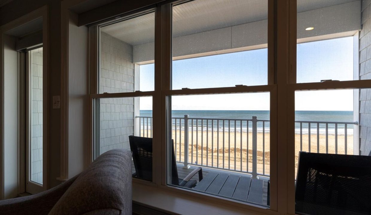 a view of a beach from a living room window.