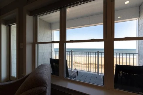 a view of a beach from a living room window.